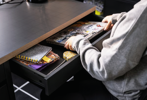 Pull-out drawer of red MICKE desk with laptop and supplies