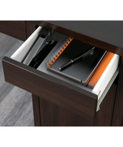 Black-brown desk drawer open with notebook, stapler, and pen inside – close-up of MICKE desk