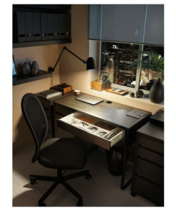 Drawer open on black-brown desk under warm light – night work setup