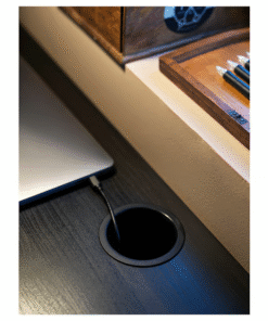 Close-up of cable outlet on black-brown desk with laptop charger