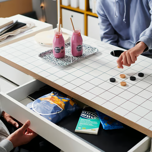 Snacks and games stored in the MICKE desk drawer