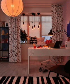 MICKE desk under soft evening lighting with decor and snacks