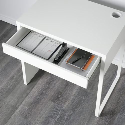 open drawer of white MICKE desk with planner and stationery
